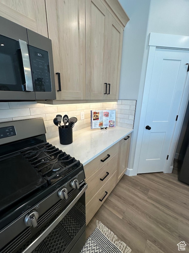 634 E Otto Ln, Grantsville, UT 84029 - kitchen with light stone counters, backsplash, appliances with stainless steel finishes, and wood finished floors