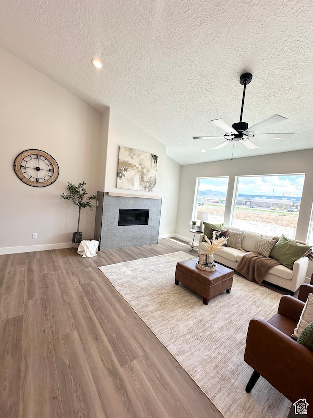 634 E Otto Ln, Grantsville, UT 84029 - living room with baseboards, a tiled fireplace, vaulted ceiling, wood finished floors, and a ceiling fan