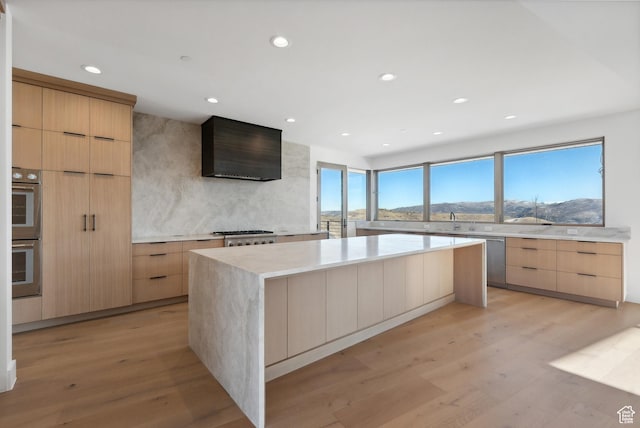7702 N Fire Ring Glade, Park City, UT 84098 - kitchen with a mountain view, a center island, wall chimney range hood, light hardwood / wood-style floors, and stainless steel appliances