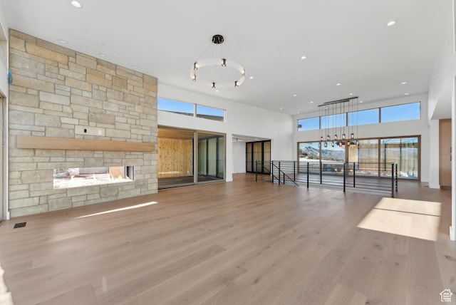 7702 N Fire Ring Glade, Park City, UT 84098 - unfurnished living room with a stone fireplace, hardwood / wood-style floors, and a high ceiling