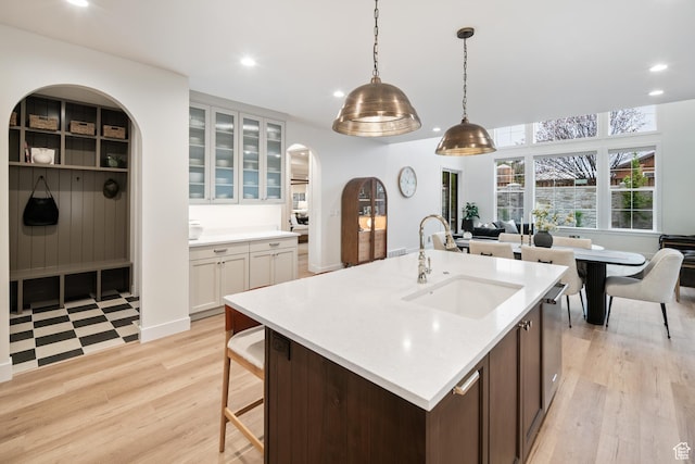 2984 N 1080 W, Lehi, UT 84043 - kitchen featuring arched walkways, light wood-style flooring, light countertops, and a sink