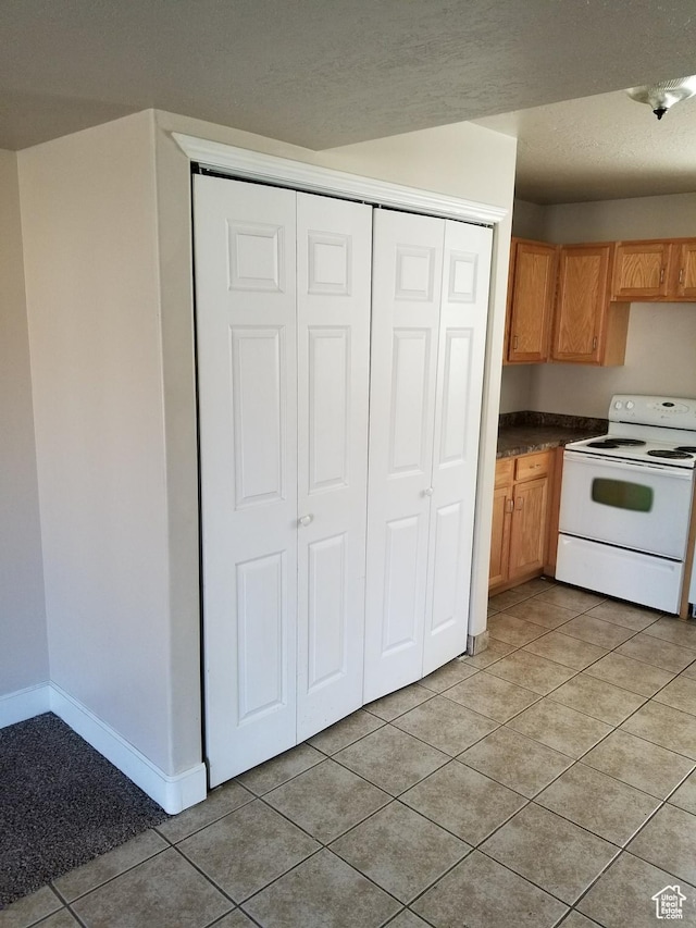 818 S 50 E, Vernal, UT 84078 - kitchen with light tile patterned floors and white range with electric cooktop