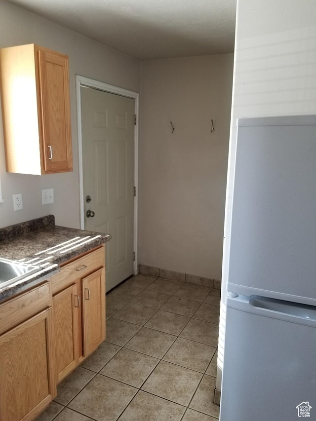 818 S 50 E, Vernal, UT 84078 - kitchen with white fridge, light tile patterned floors, and light brown cabinetry