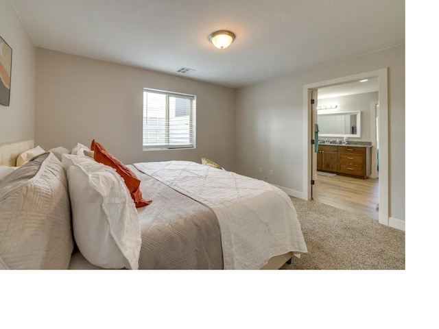 bedroom with carpet floors, visible vents, baseboards, and ensuite bathroom