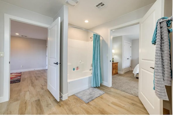 ensuite bathroom featuring baseboards, visible vents, wood finished floors, shower / bathtub combination with curtain, and recessed lighting