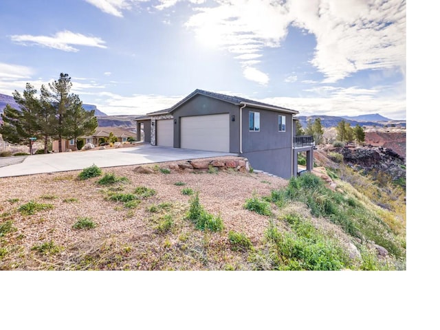 garage with concrete driveway and a mountain view