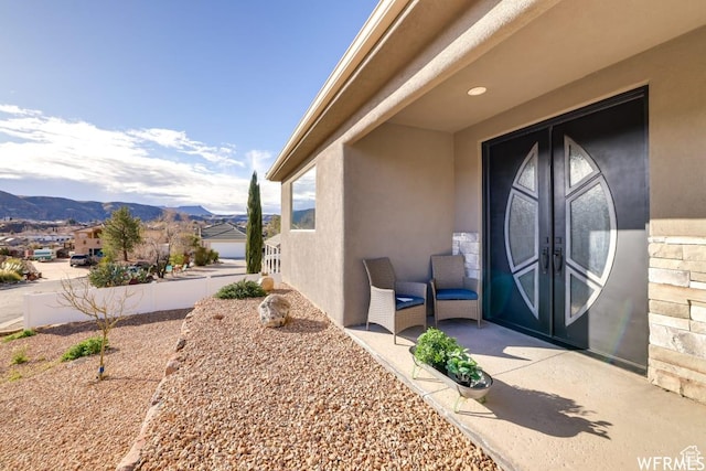 property entrance featuring french doors, a mountain view, and stucco siding