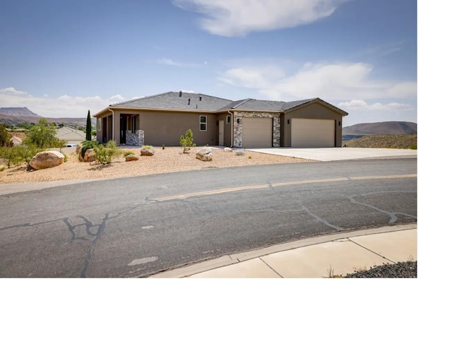 view of front of house featuring driveway, an attached garage, and stucco siding