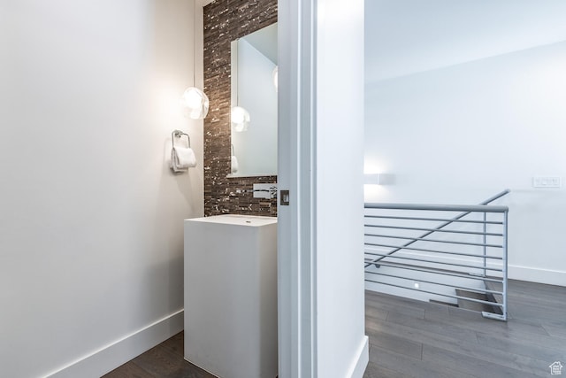 2752 W High Rd Unit 1501, Park City, UT 84098 - bathroom featuring tasteful backsplash, vanity with extensive cabinet space, brick wall, and hardwood / wood-style floors