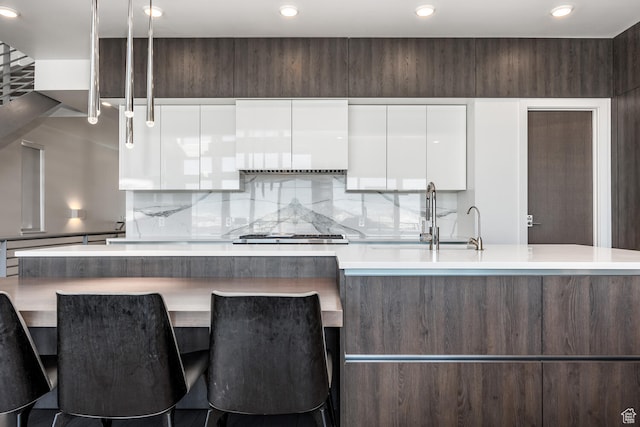 2752 W High Rd Unit 1501, Park City, UT 84098 - kitchen with a kitchen island, backsplash, stainless steel gas cooktop, white cabinets, and sink