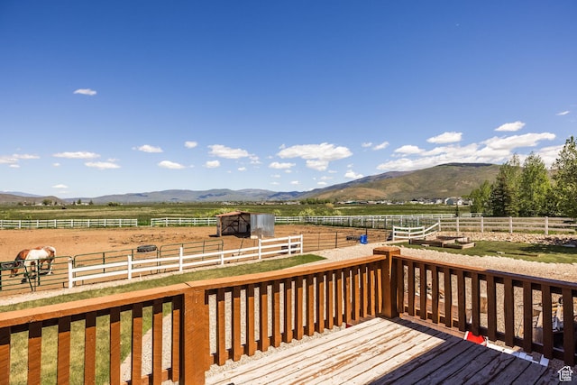 wooden terrace with an enclosed area, a rural view, and a mountain view
