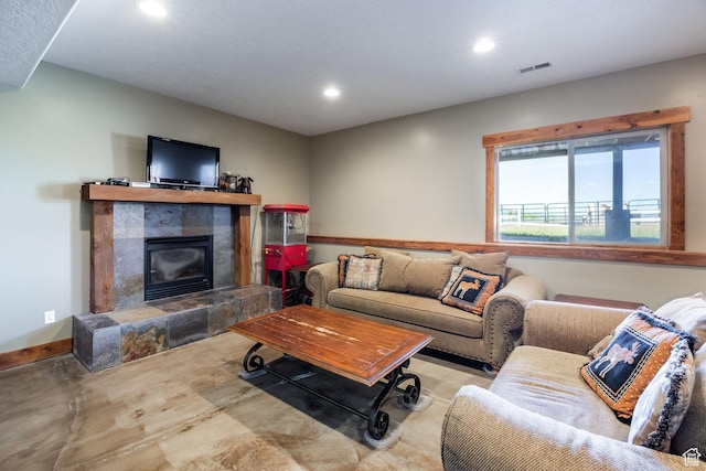living area featuring recessed lighting, visible vents, baseboards, and a tiled fireplace
