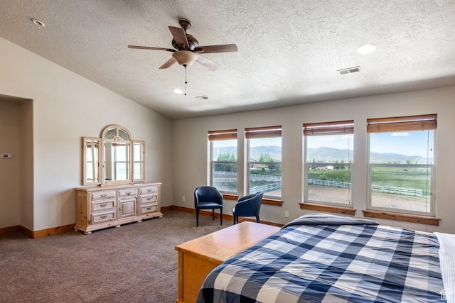 carpeted bedroom with visible vents, a textured ceiling, baseboards, lofted ceiling, and ceiling fan