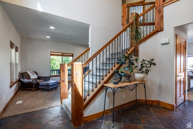 staircase with recessed lighting, baseboards, and stone tile flooring