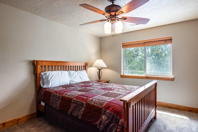 bedroom with baseboards, carpet, a ceiling fan, and a textured ceiling