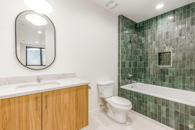 full bath featuring baseboards, toilet, vanity, tiled shower / bath combo, and tile patterned flooring