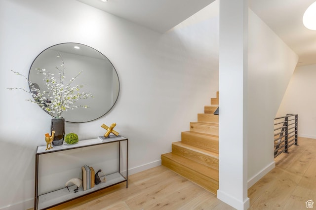 stairway with wood finished floors and baseboards
