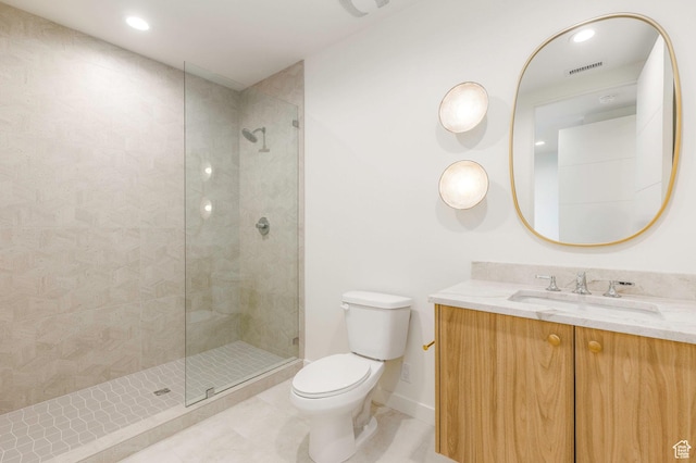 bathroom with visible vents, a tile shower, toilet, vanity, and tile patterned floors