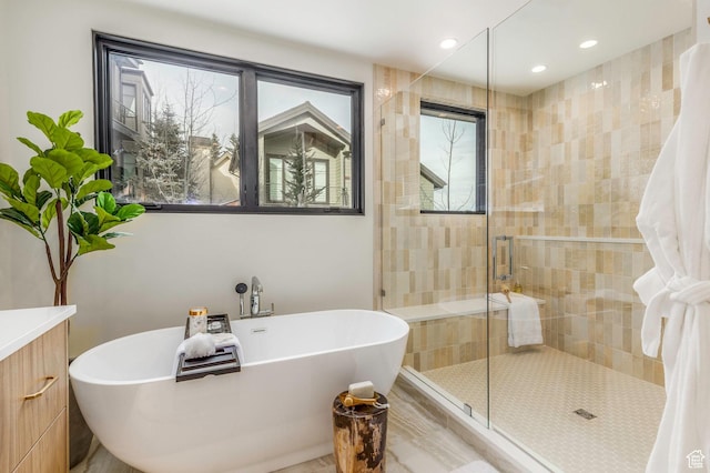 full bathroom with a freestanding bath, a shower stall, and a healthy amount of sunlight