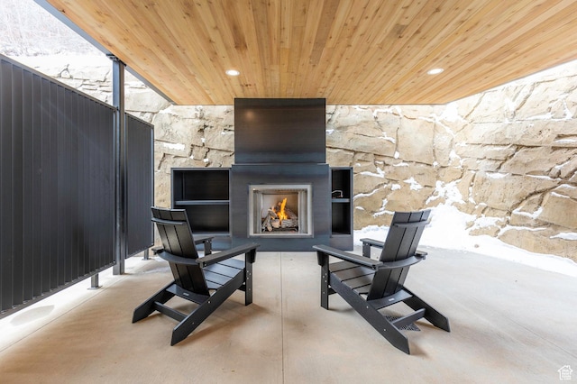 view of patio with a warm lit fireplace