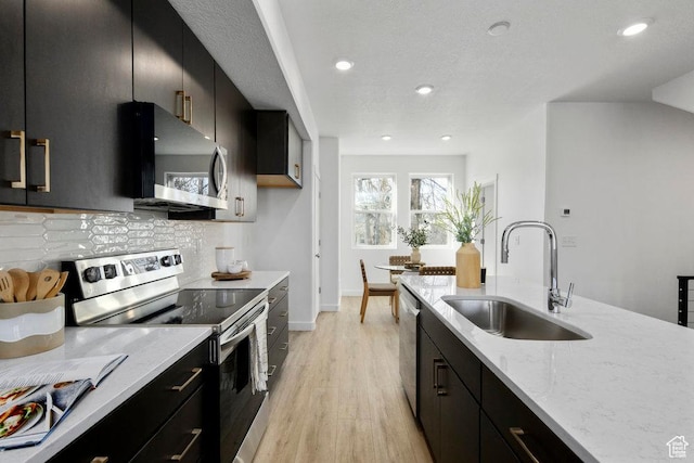 439 N 268 W Unit 4-18, Salt Lake City, UT 84103 - kitchen featuring stainless steel appliances, a sink, dark cabinets, decorative backsplash, and recessed lighting