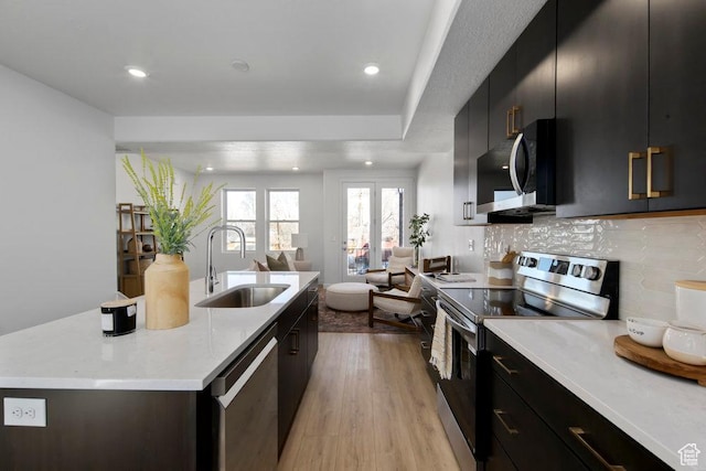 439 N 268 W Unit 4-18, Salt Lake City, UT 84103 - kitchen featuring stainless steel appliances, a sink, open floor plan, light countertops, and an island with sink