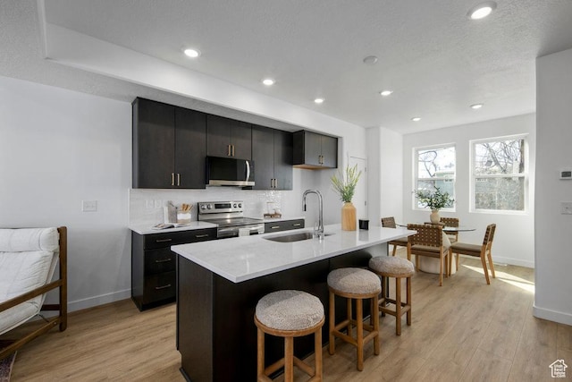 439 N 268 W Unit 4-18, Salt Lake City, UT 84103 - kitchen with stainless steel appliances, a sink, a breakfast bar area, baseboards, and recessed lighting
