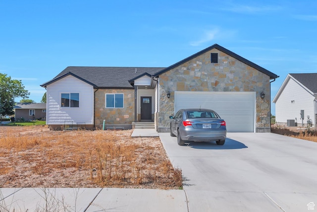 ranch-style house with stone siding, a garage, driveway, and roof with shingles