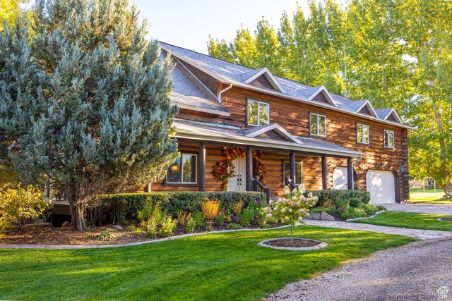 3383 Wild Mare Way, Heber City, UT 84032 - log cabin featuring a garage, a front yard, log exterior, covered porch, and driveway