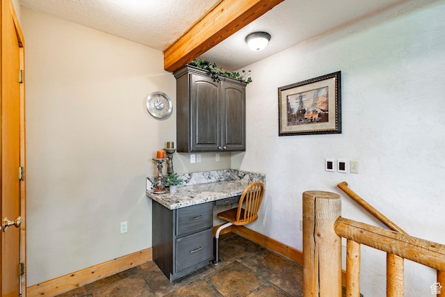 3383 Wild Mare Way, Heber City, UT 84032 - office space featuring baseboards, built in desk, a textured ceiling, beamed ceiling, and dark stone finish flooring
