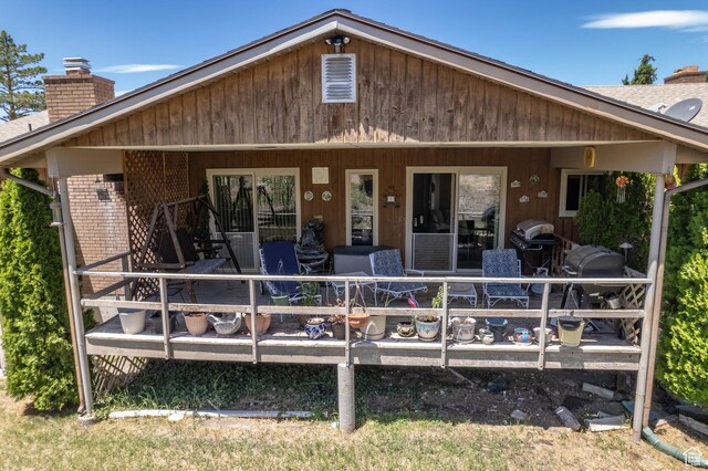 2317 N Hillside Dr, Wellington, UT 84542 - back of house with a chimney, brick siding, roof with shingles, and a deck