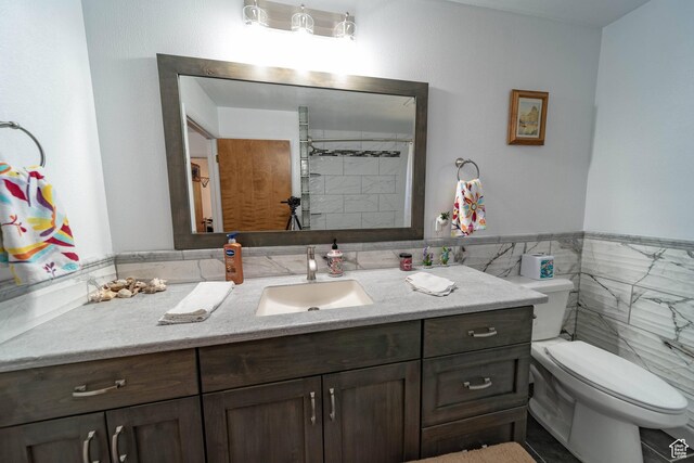 2317 N Hillside Dr, Wellington, UT 84542 - full bathroom with tile walls, toilet, vanity, and a wainscoted wall