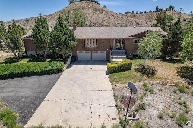 2317 N Hillside Dr, Wellington, UT 84542 - single story home with a front lawn, a chimney, concrete driveway, a garage, and brick siding