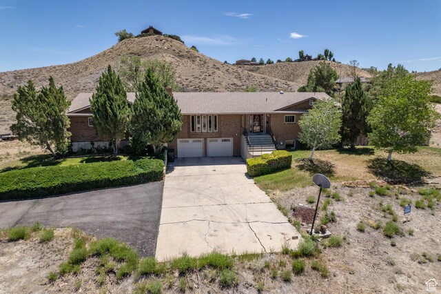 2317 N Hillside Dr, Wellington, UT 84542 - single story home with concrete driveway, brick siding, a mountain view, and a garage