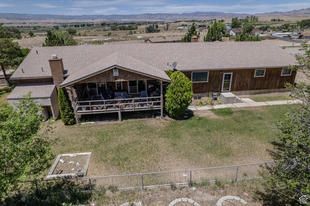 2317 N Hillside Dr, Wellington, UT 84542 - back of house with a chimney, fence, a yard, roof with shingles, and a mountain view