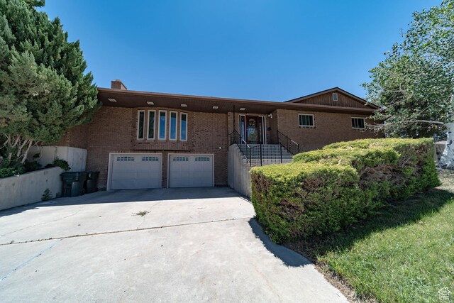 2317 N Hillside Dr, Wellington, UT 84542 - ranch-style house featuring brick siding, a chimney, a garage, and concrete driveway