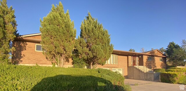 2317 N Hillside Dr, Wellington, UT 84542 - view of side of home featuring driveway, brick siding, and a garage