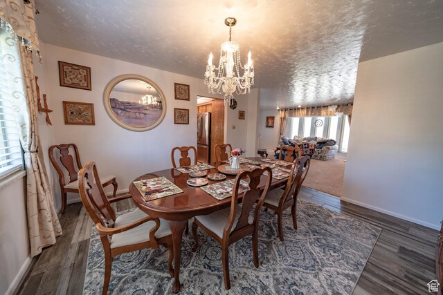 2317 N Hillside Dr, Wellington, UT 84542 - dining space with wood finished floors, a textured ceiling, baseboards, and a notable chandelier