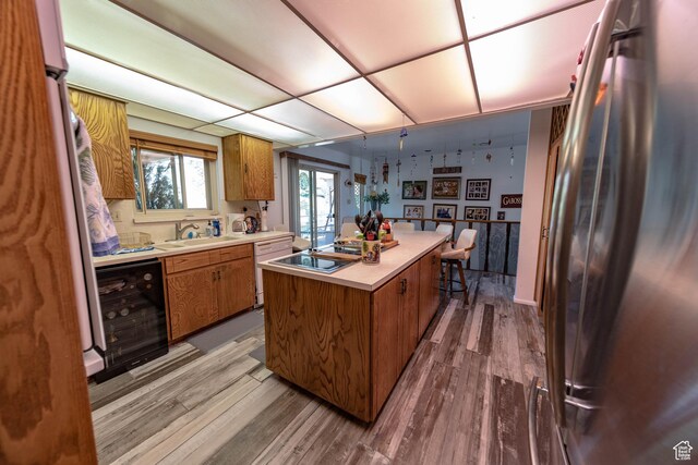 2317 N Hillside Dr, Wellington, UT 84542 - kitchen featuring freestanding refrigerator, beverage cooler, brown cabinetry, and a sink