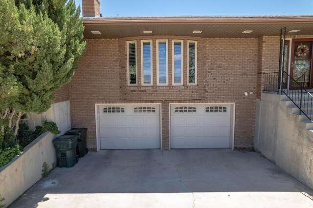 2317 N Hillside Dr, Wellington, UT 84542 - view of property exterior featuring a garage, driveway, a chimney, and brick siding