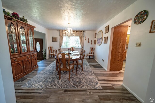 2317 N Hillside Dr, Wellington, UT 84542 - dining area with a chandelier, baseboards, a textured ceiling, and dark wood-type flooring