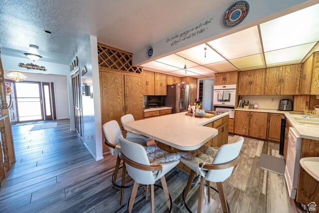 2317 N Hillside Dr, Wellington, UT 84542 - kitchen featuring brown cabinetry, wooden walls, stainless steel fridge with ice dispenser, light countertops, and a kitchen island