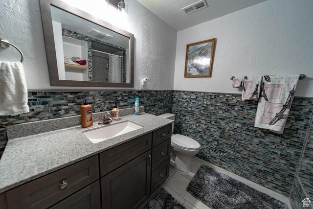 2317 N Hillside Dr, Wellington, UT 84542 - full bath with visible vents, toilet, vanity, tile walls, and a shower with shower curtain