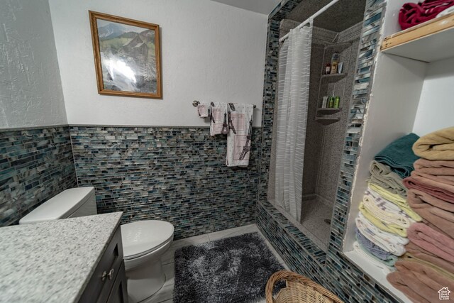 2317 N Hillside Dr, Wellington, UT 84542 - bathroom with a stall shower, vanity, tile walls, toilet, and tile patterned flooring