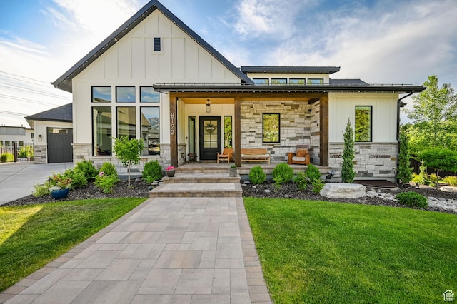 8122 S Willow Creek Cv, Cottonwood Heights, UT 84093 - view of front of house featuring a garage, a front yard, and covered porch