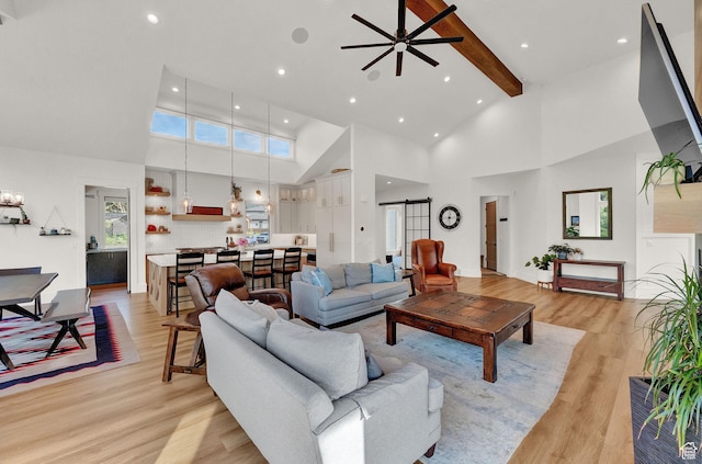 8122 S Willow Creek Cv, Cottonwood Heights, UT 84093 - living room featuring beamed ceiling, a barn door, high vaulted ceiling, and light hardwood / wood-style flooring