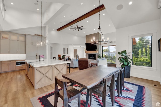 8122 S Willow Creek Cv, Cottonwood Heights, UT 84093 - dining room featuring high vaulted ceiling, beamed ceiling, a large fireplace, sink, and light hardwood / wood-style floors