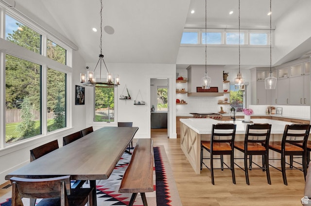 8122 S Willow Creek Cv, Cottonwood Heights, UT 84093 - dining space with a wealth of natural light, light hardwood / wood-style flooring, and high vaulted ceiling