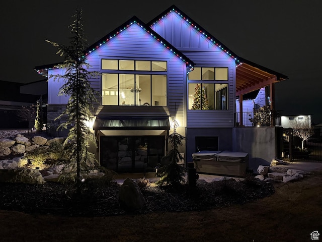 8122 S Willow Creek Cv, Cottonwood Heights, UT 84093 - back house at twilight featuring a hot tub and a garage
