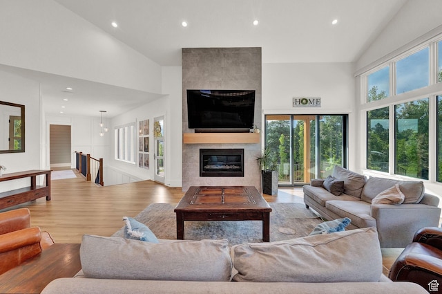 8122 S Willow Creek Cv, Cottonwood Heights, UT 84093 - living room with a tile fireplace, high vaulted ceiling, and light wood-type flooring